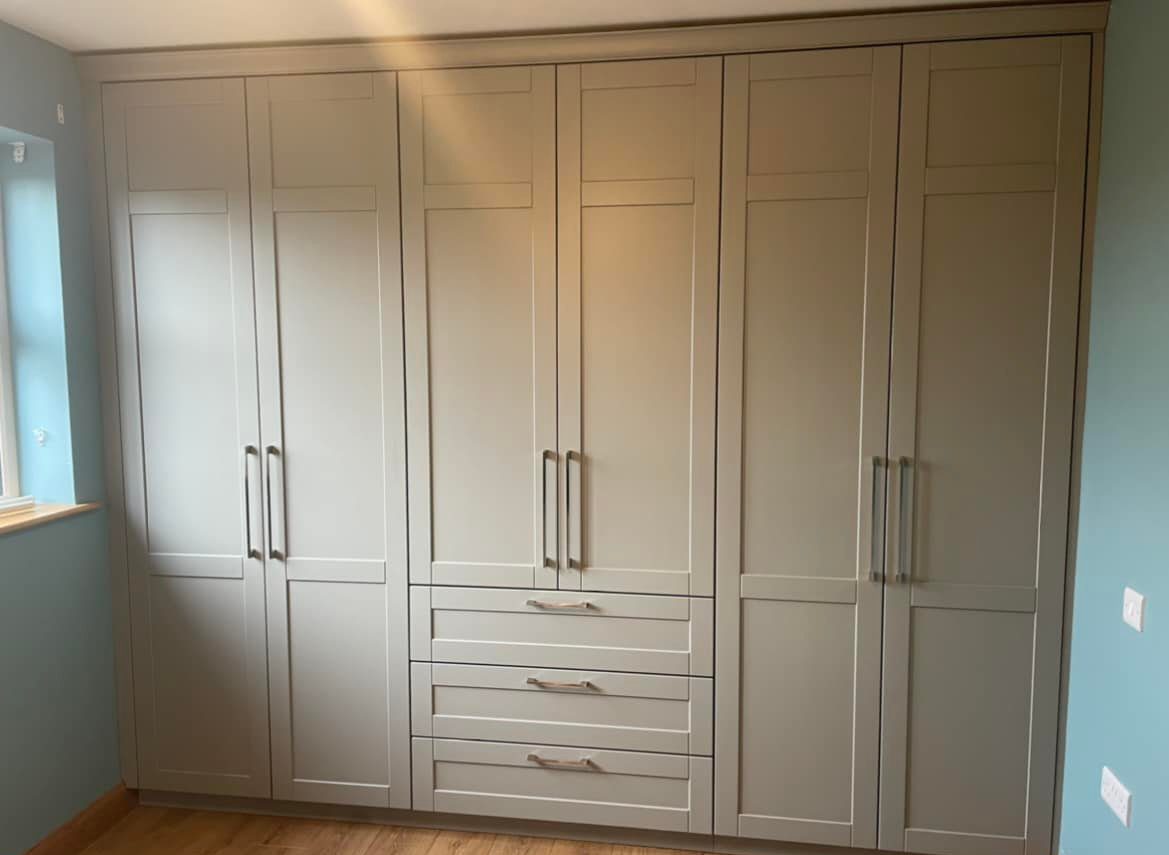 grey fitted wardrobe in a blue bedroom