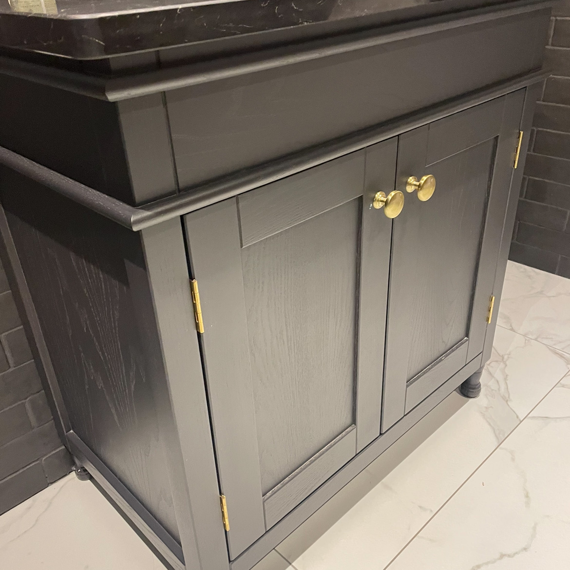 Black under sink cabinet with gold accents
